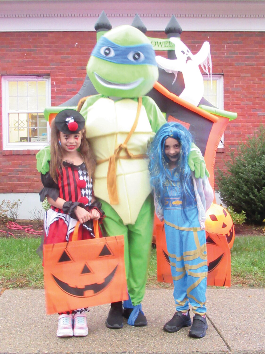 PARENTE’S PALS: Kathy Parente (a.k.a. the Ninja Turtle) is joined by two of the countless children who took in Monday’s Trunk or Treat.